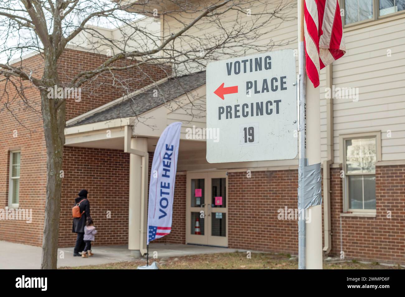 Deaarborn, Michigan, USA. Februar 2024. Eine Wählerin und ihr Kind kommen zur Wahl an der Geer Park School bei der Präsidentschaftswahl in Michigan. Vor allem in Hamtramck und Dearborn, wo es eine große Zahl von Arabisch-Amerikanern gibt, planten viele Wähler, in der demokratischen Vorwahl „ungebunden“ zu wählen. Viele Araber-Amerikaner sind wütend über Joe Bidens Unterstützung für Israel im Gaza-Krieg. Quelle: Jim West/Alamy Live News Stockfoto