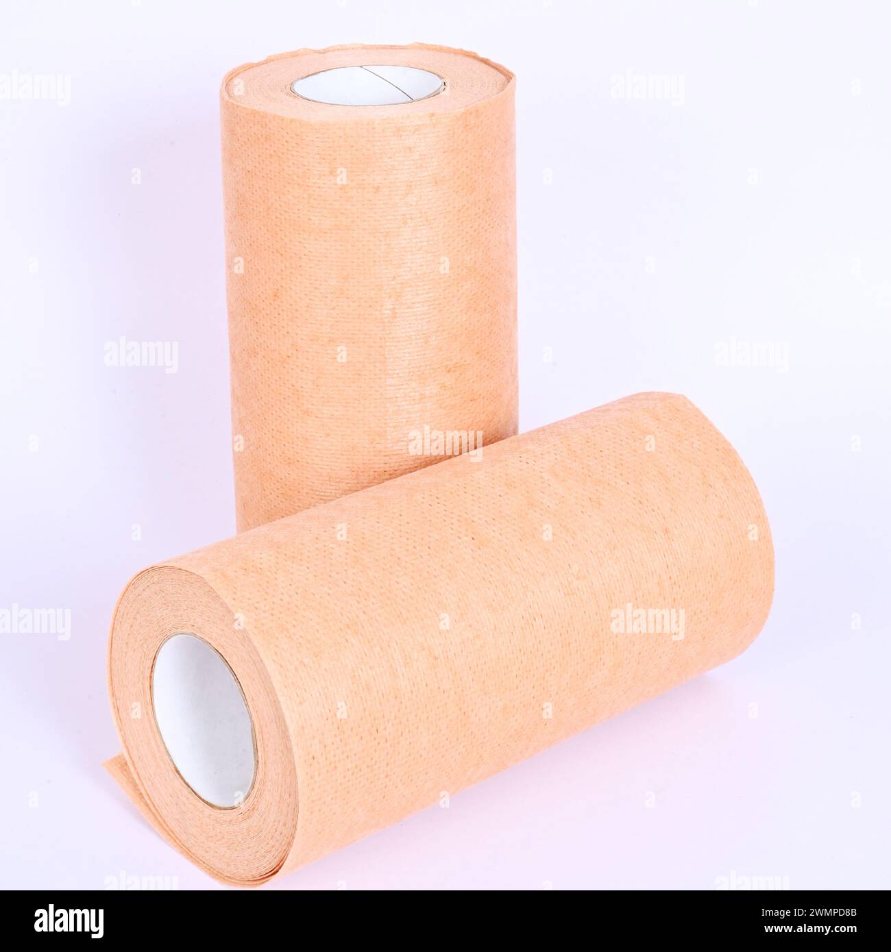 Braunes Tuch überrollen auf weißem Hintergrund. Abwaschbares braunes Tissue-Papier, Rolle über weißem Hintergrund, 2er-Pack. Vliesstoffrolle. Stockfoto