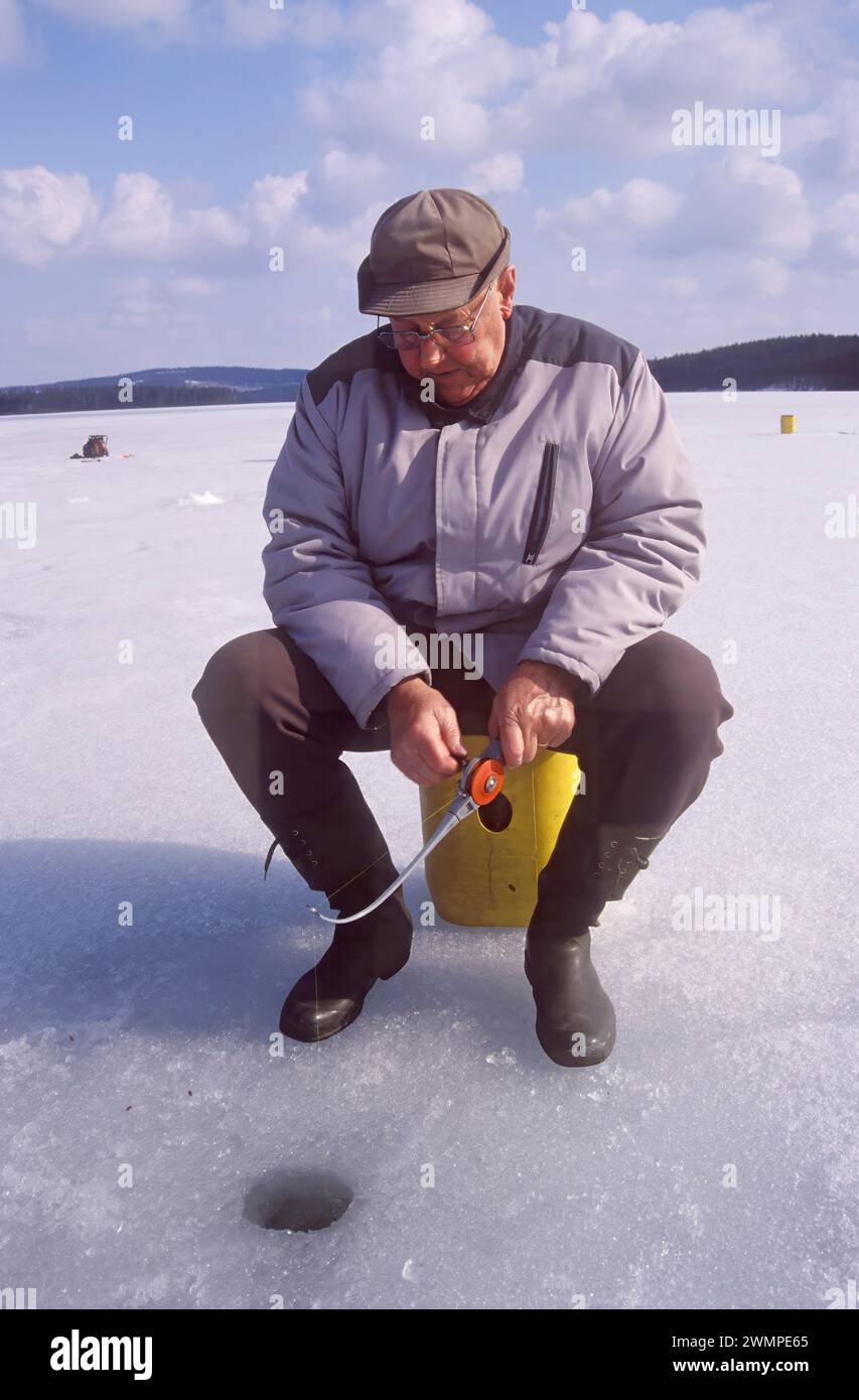 Alter Mann Eisfischen Stockfoto