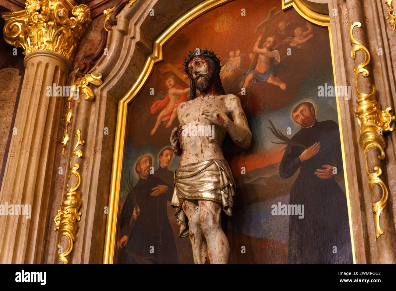 Posen, Polen – 18. Juni 2023: Ein Kruzifix steht vor einem Gemälde, das Jesus darstellt und religiösen Symbolismus und Ehrfurcht veranschaulicht. Stockfoto