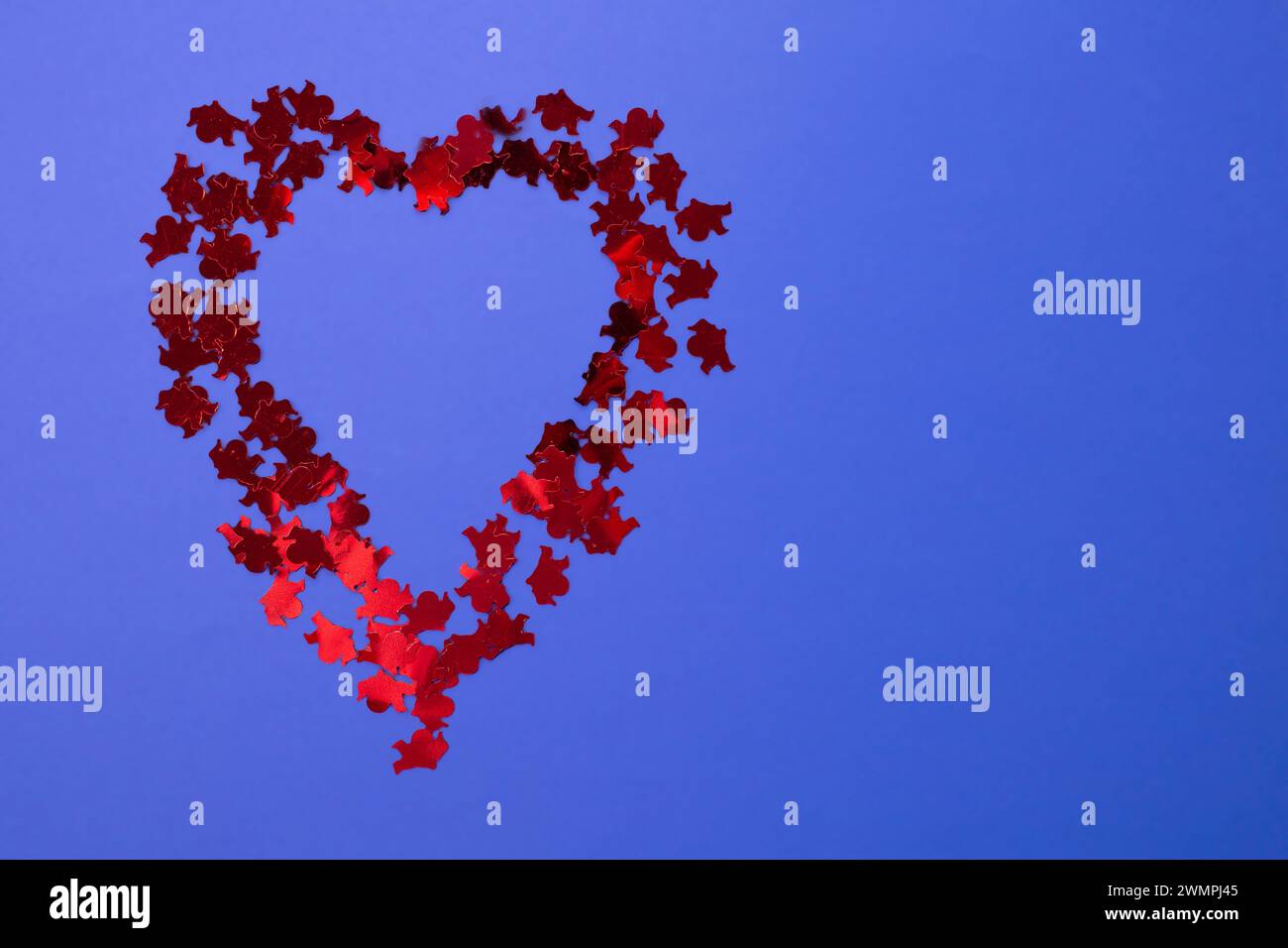 Herz aus kleinen Cupiden auf blauem Hintergrund. Kopierbereich. Flache Lagen Stockfoto