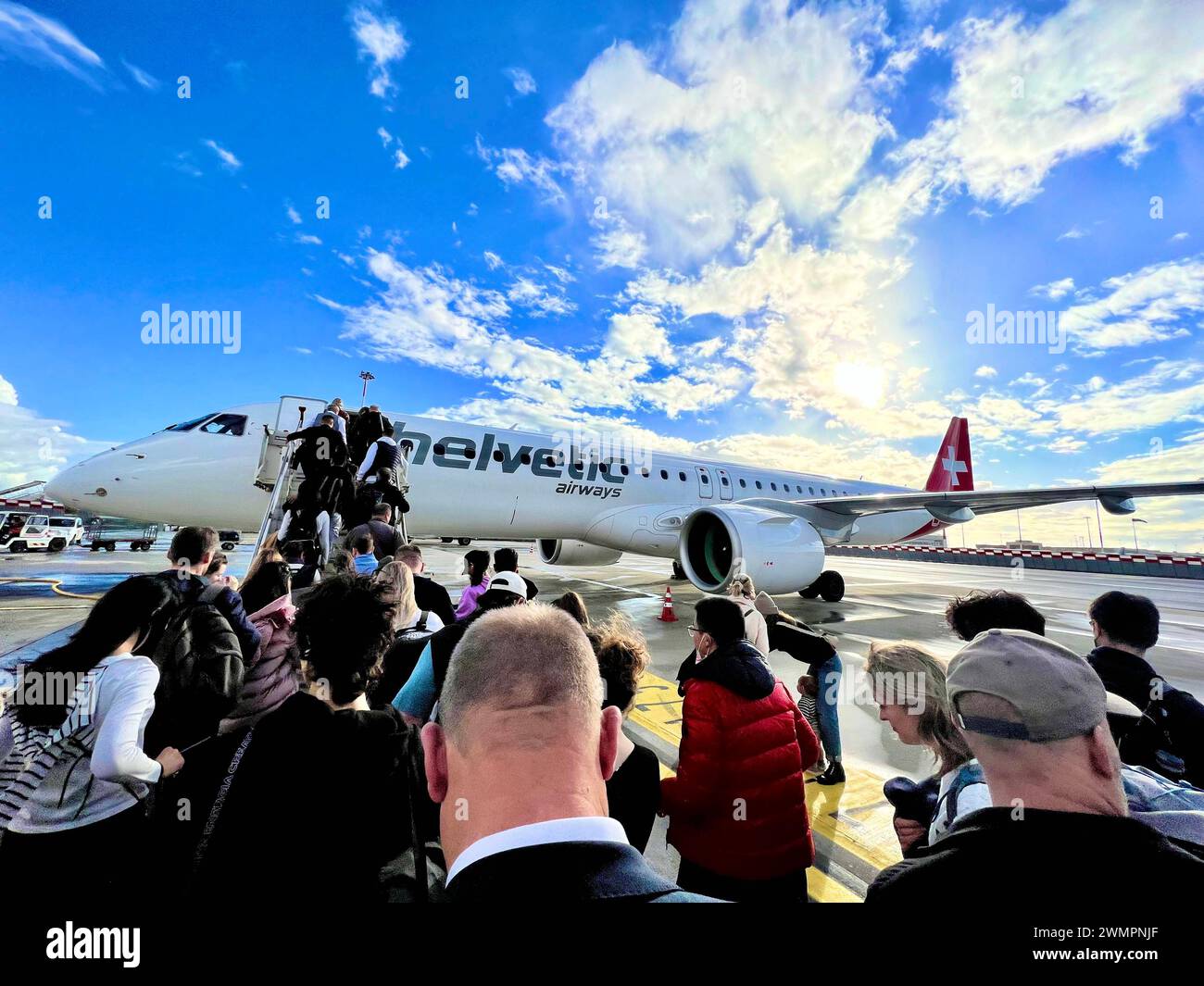 Boarding mit Passagieren auf dem Rollfeld des Flughafens der Schweizer Fluggesellschaft Helvetic Airways, die im Auftrag der Swiss operiert. Embraer 195 Schweiz *** Einsteigen mit Fluggästen auf dem Rollfeld am Flughafen der Schweizer Fluggesellschaft Helvetic Airways, die im Auftrag der Swiss Embraer 195 Schweiz tätig ist Copyright: XJoeranxSteinsiekx Stockfoto