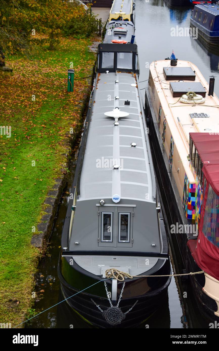 Schmalboot auf einem Anlegeplatz auf einem Kanal auf den Binnenwasserstraßen Großbritanniens. Stockfoto
