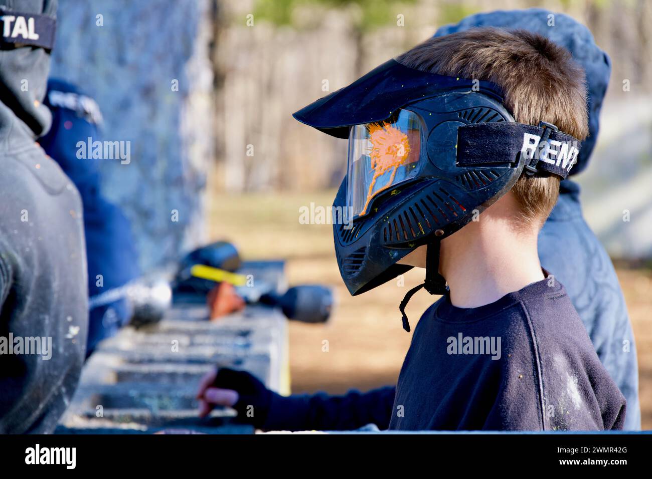 Loudoun County, Virginia, USA - 25. Februar 2024: Ein Paintballspieler trifft seine Gesichtsmaske von einem orangen Farbpellet. Stockfoto