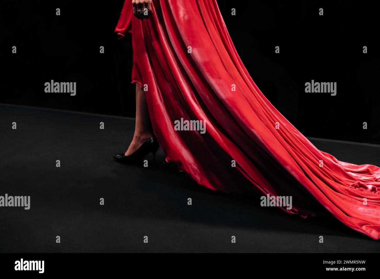 Rotes Samtkleid mit langem Saum. Damenbekleidung elegantes Outfit. Seitenansicht Stockfoto