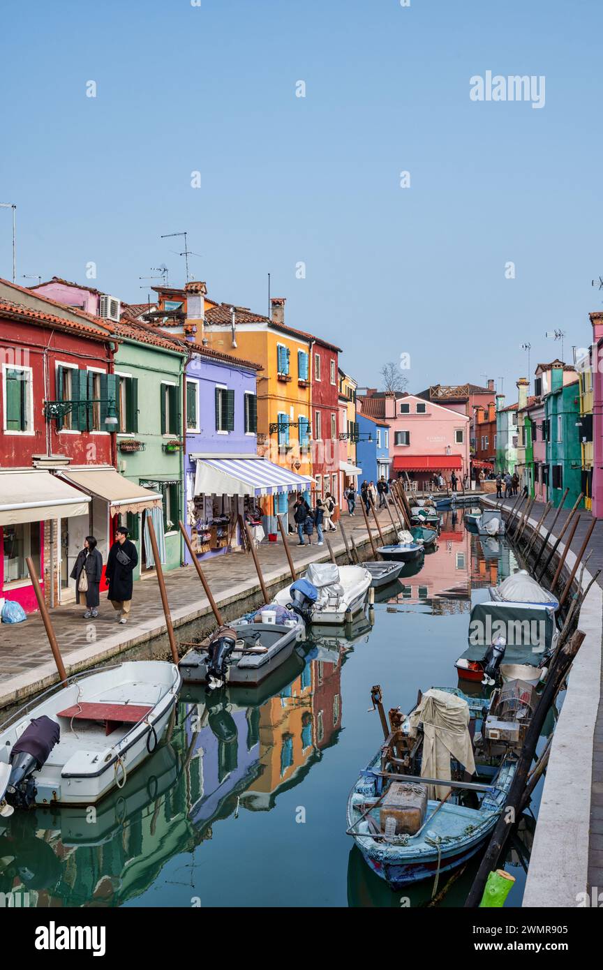 Burano, Italien - 25. Februar 2023; farbenfrohe Häuser entlang des Hauptkanals mit kleinen Booten in Burano Italien Stockfoto