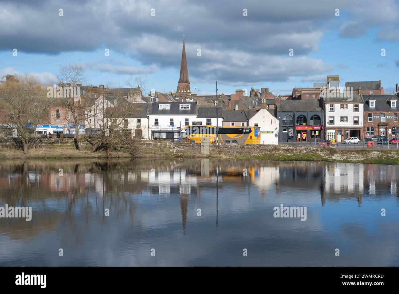 Ein Blick über den Fluss Nith mit den Whitesands in Dumfries, Schottland. Bei der Ankunft eines Stagecoach-Busses werden Passagiere abgeholt. Stockfoto