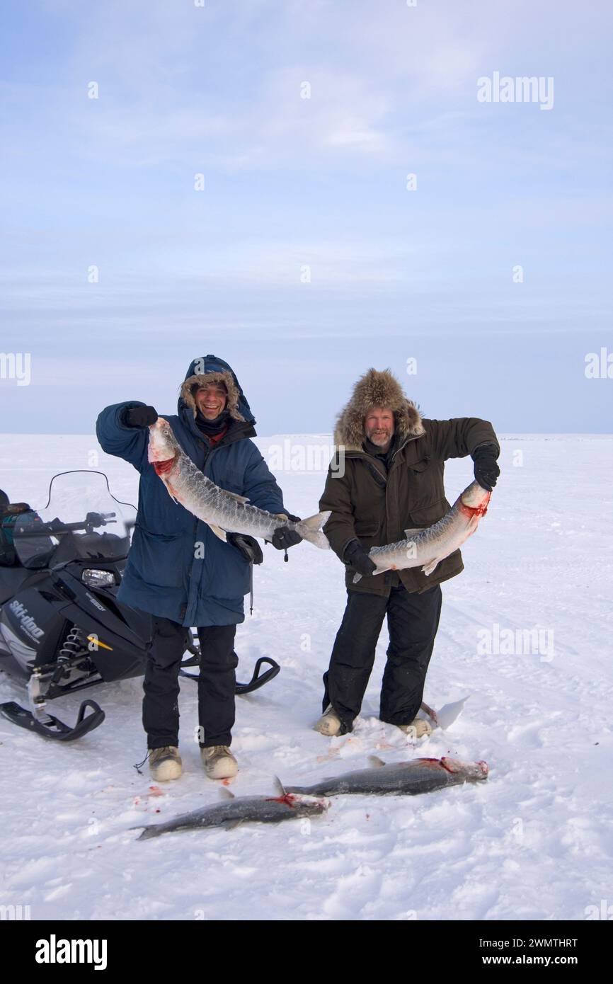 Steven Kazlowski und Tim Cook führen beim Eisangeln auf Schaffische am Kotzebue Sound außerhalb der Dorfstadt Kotzebue Sound im Nordwesten der Arktis Alaska Stockfoto