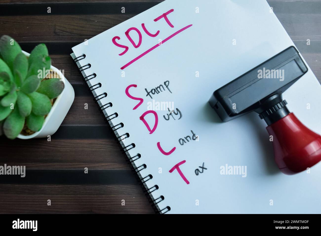 Konzept der SDLT - Stempelgebühr Grundsteuer auf Buch isoliert auf Holztisch schreiben. Stockfoto