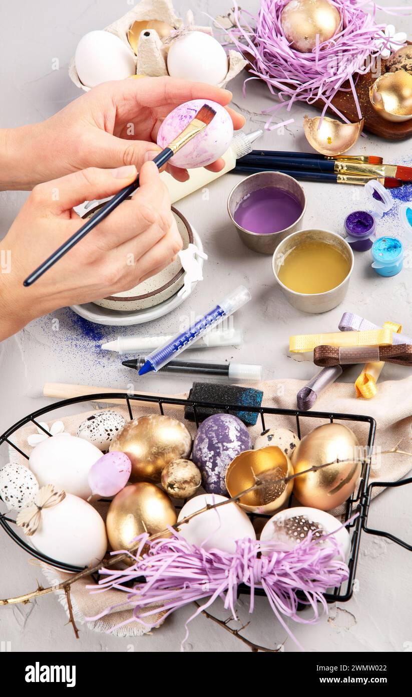 Frohe Ostern, Eier malen. Farben, Stifte, Dekorationen zum Färben von Eiern für den Urlaub auf weißem Hintergrund. Draufsicht. Stockfoto