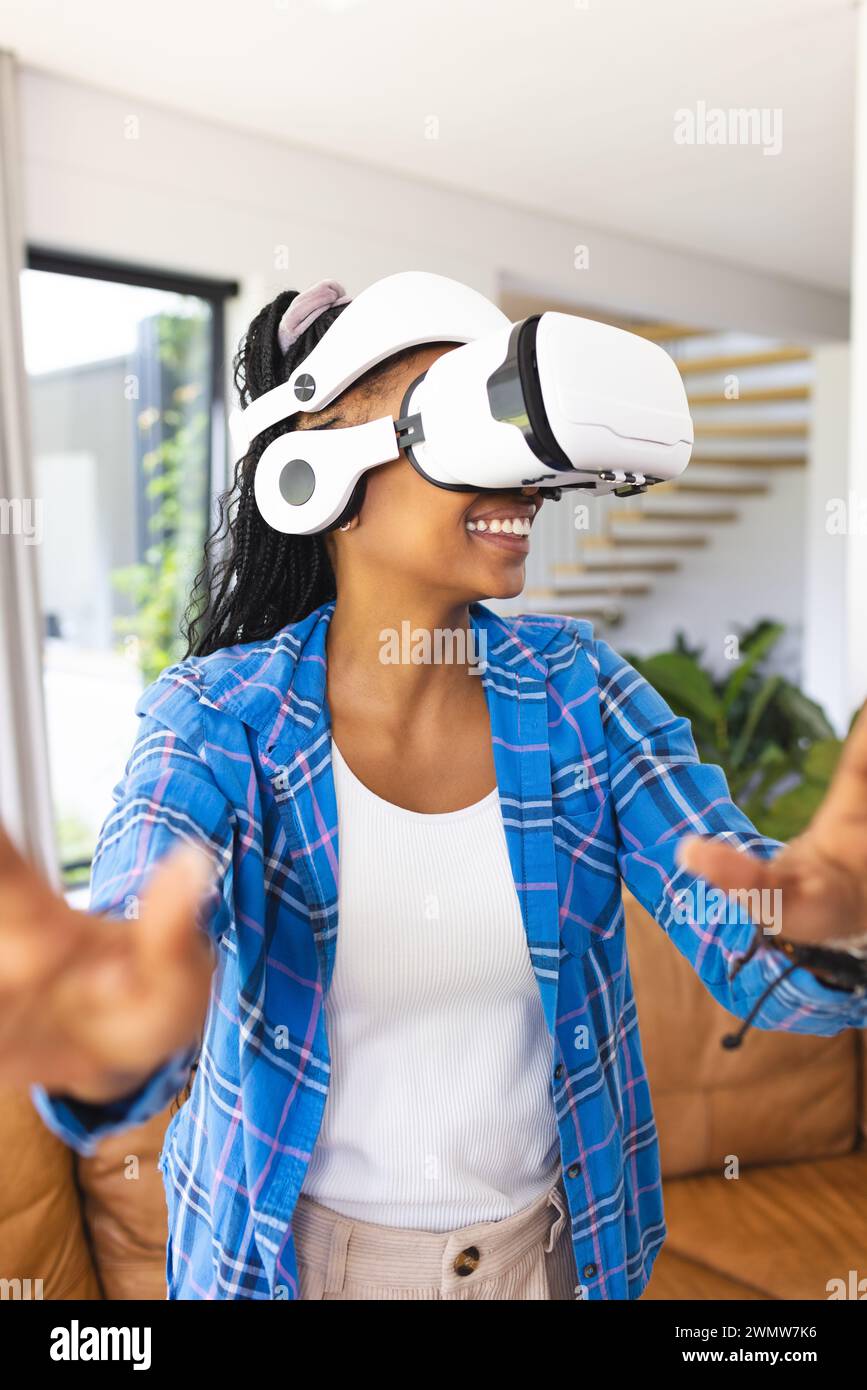 Die junge afroamerikanische Frau erkundet die virtuelle Realität mit einem VR-Headset Stockfoto