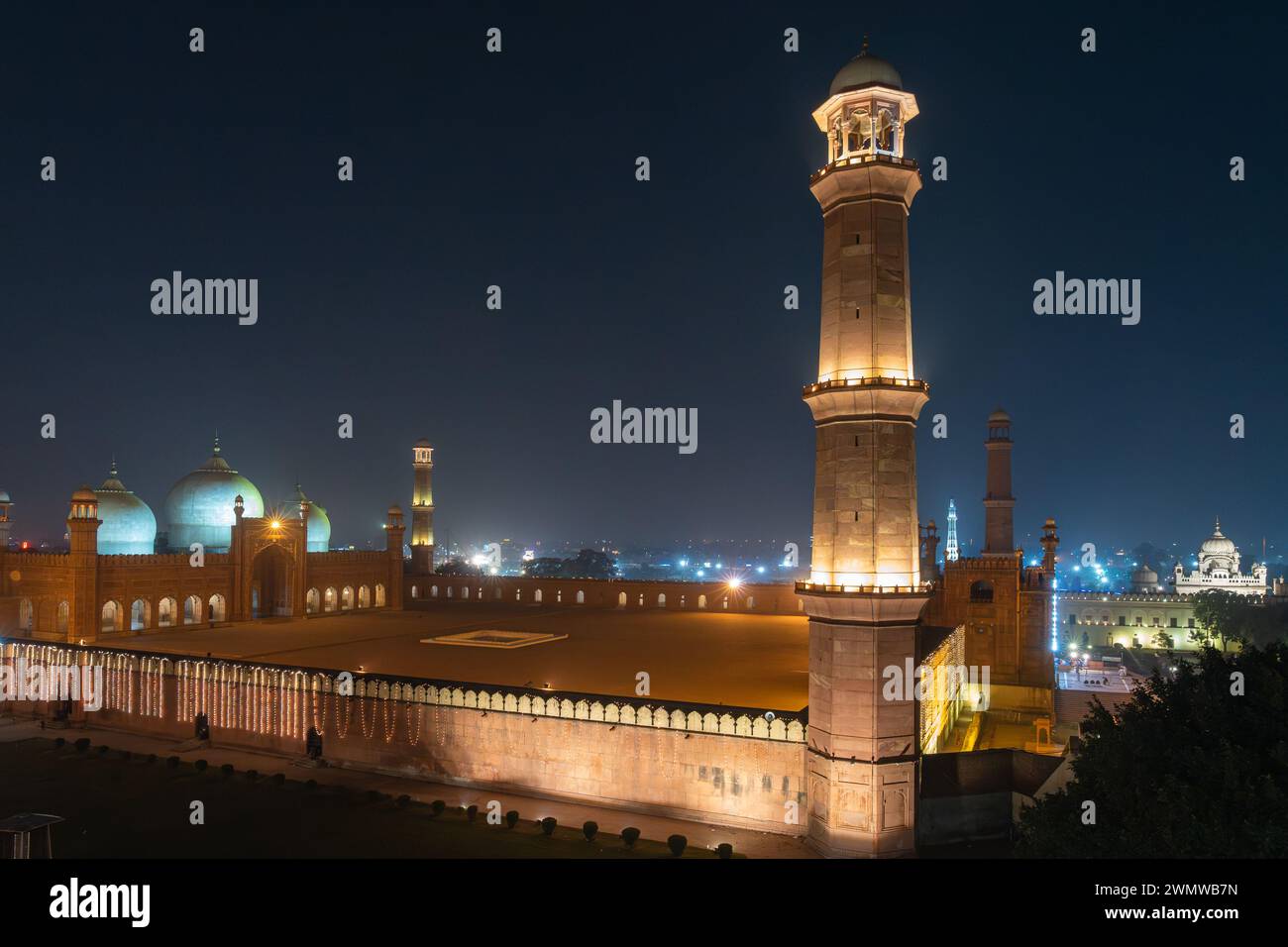 Nächtlicher Blick auf die Stadt auf der beleuchteten antiken Badshahi-Moschee, die vom mogulkaiser Aurangzeb vor dem Fort Lahore in Punjab, Pakistan erbaut wurde Stockfoto