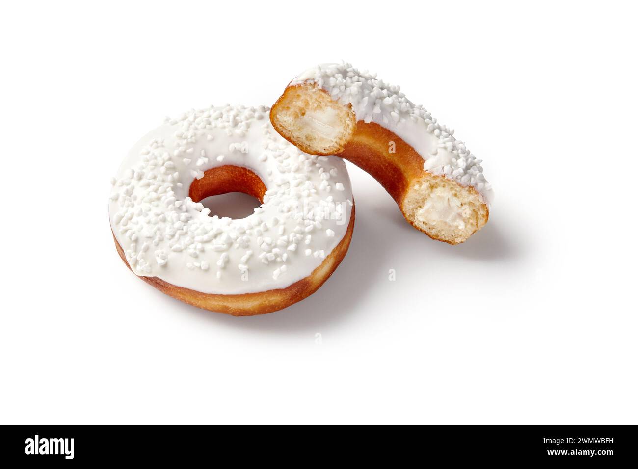 Zwei süße weiche Donuts mit cremiger Füllung, weißer Vanilleglasur und Zuckerstreuseln auf nahtlosem weißem Hintergrund. Beliebte Süßwaren Stockfoto