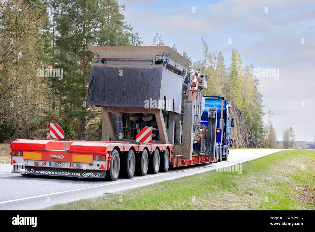 Scania Lkw-Auflieger PHP Group Oy transportiert Brechmaschinen als Übergröße entlang der Autobahn 52, Rückansicht. Salo, Finnland. Mai 2022. Stockfoto
