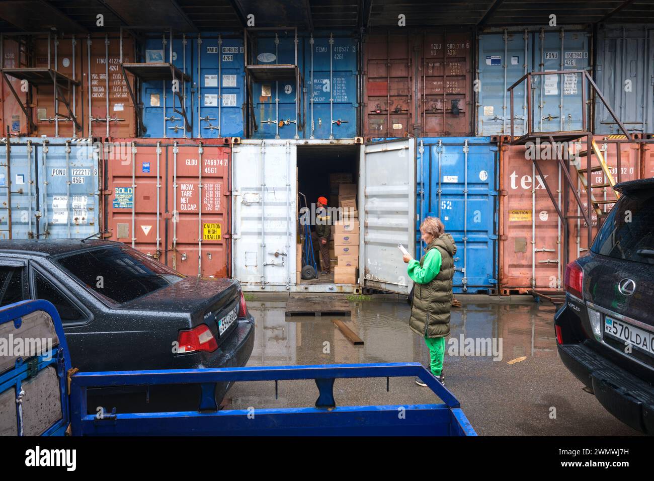 Ein paar Anbieter, die mit ihrem offenen Versandbehälter Vorräte abholen. Auf dem Barakholka Versandcontainer lokalen Markt in Almaty, Kasachstan Stockfoto