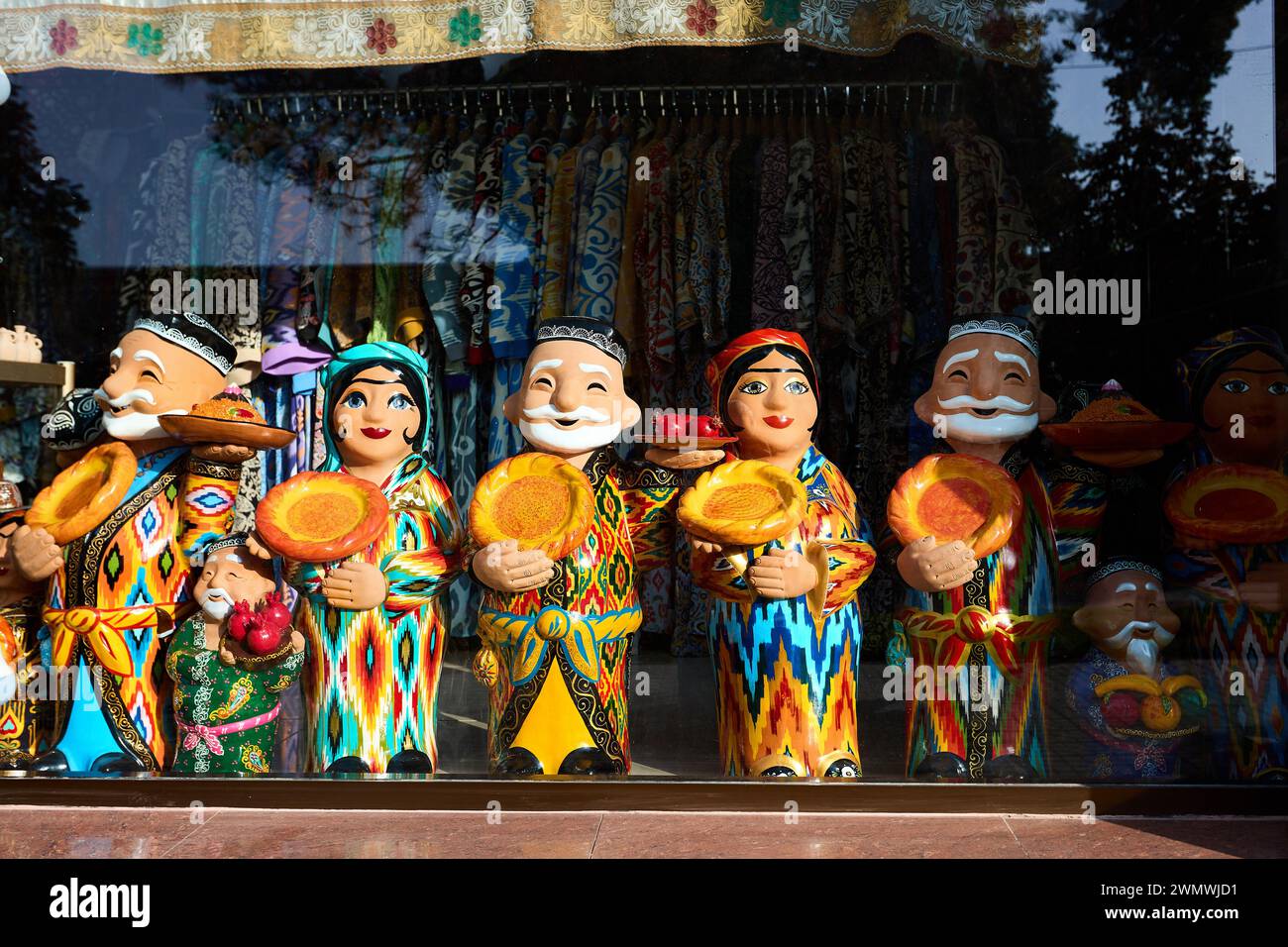 Keramikfiguren usbekischer alter Männer und Frauen in traditioneller Kleidung mit rundem Brot Lepeshka im Souvenirladen in Samarkand, Usbekistan Stockfoto