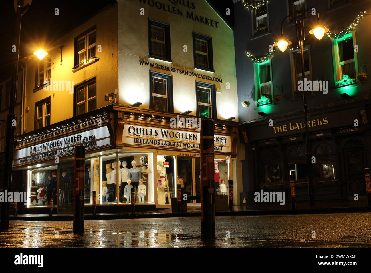 Killarney High Street in der Nacht im Winter nach dem Regen im County Kerry Irland. Nächtlicher Blick auf die kleine Stadt Stockfoto