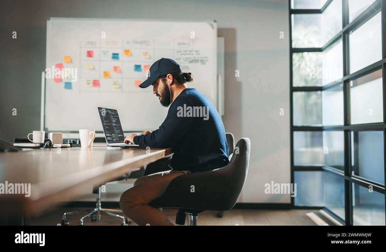 Fokussierte junge Berufsregeln in einem modernen Büro. Dieser Mitarbeiter eines Technologieunternehmens ist Softwaredesigner und Webentwickler und trägt zu innovativen Profis bei Stockfoto
