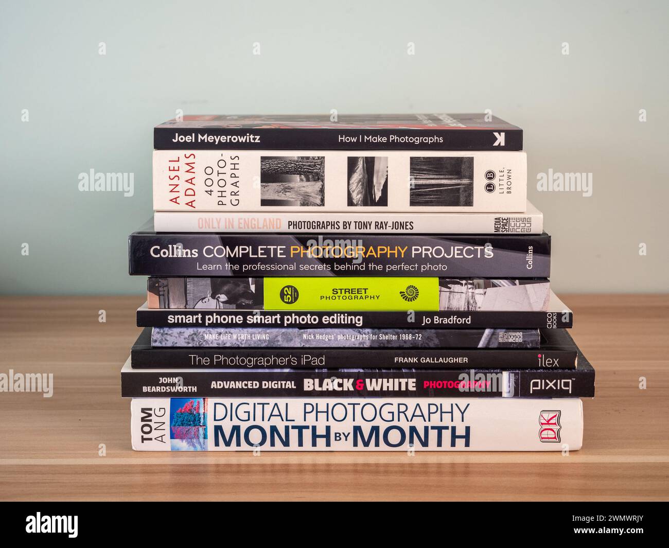 Stapel von Fotobüchern auf einem Holztisch; Konzept für Fotografie als Hobby, Zeitvertreib, Interesse usw. Stockfoto