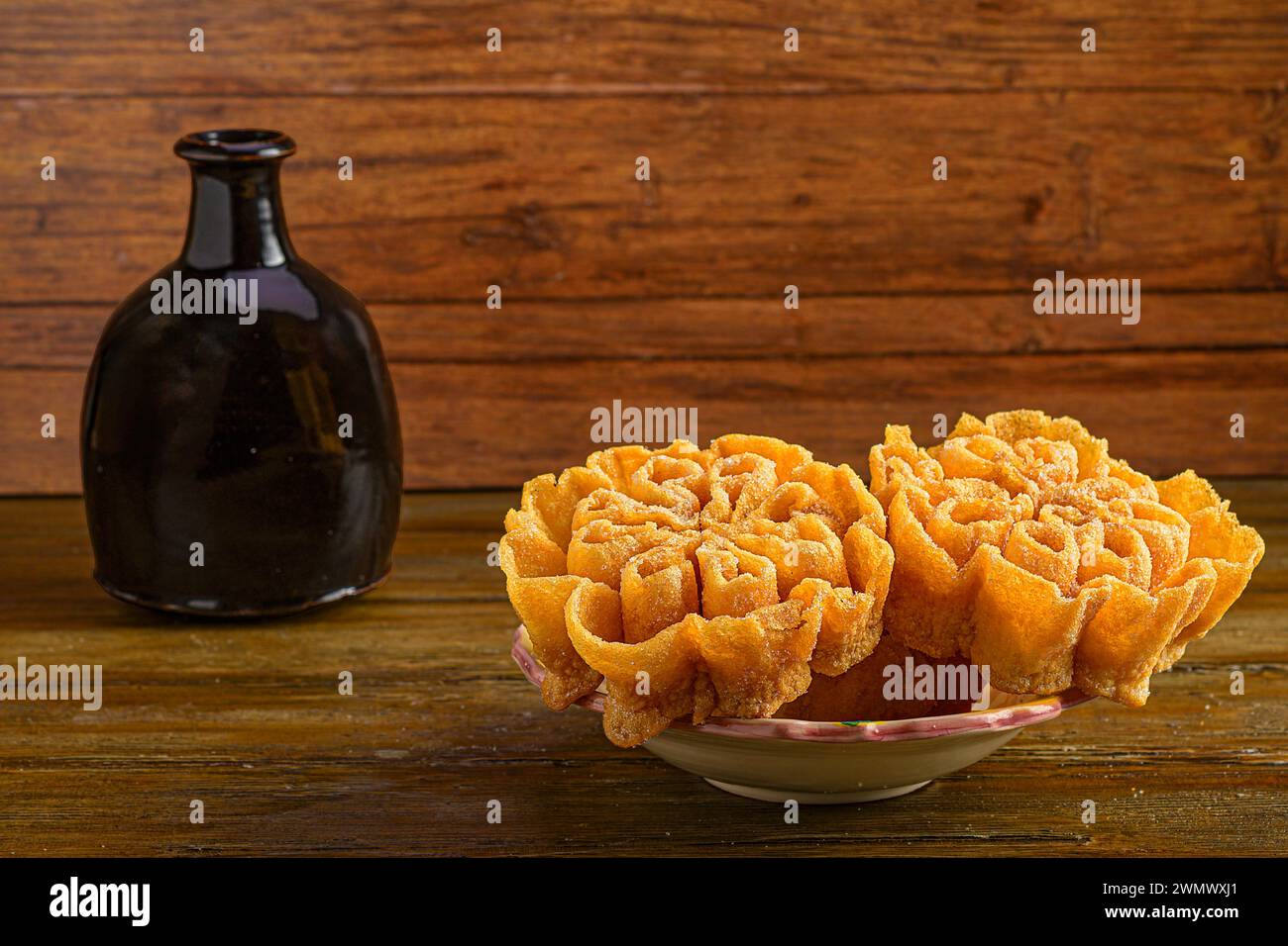 Die hausgemachten Köstlichkeiten: Gebäckblumen mit Flasche im Hintergrund Stockfoto