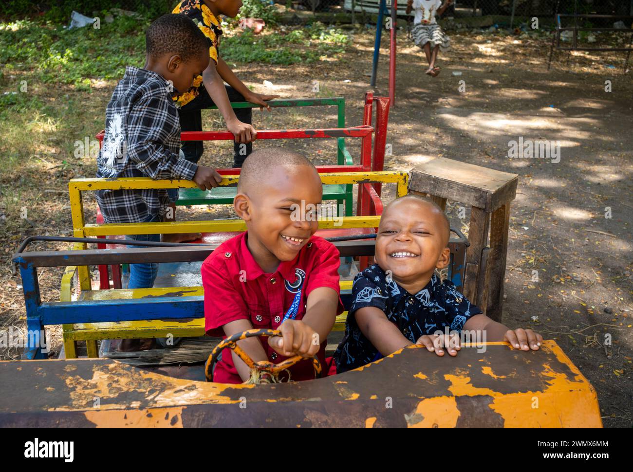 Kleine Kinder spielen in Stone Town, Sansibar, Tansania auf einer zerschlagenen Schaukel Stockfoto