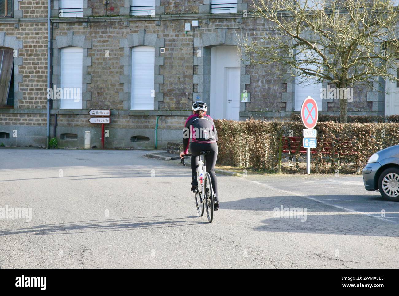 Eine junge Dame radelt durch die Straßen von Saint-Fraimbault, Normandie, Frankreich, Europa Stockfoto