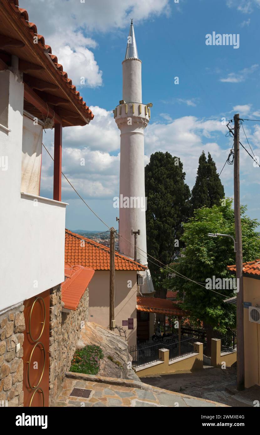 Ein weißes Minarett erhebt sich vor einem blauen Himmel neben traditionellen Gebäuden, Xanthi, Ostmakedonien und Thrakien, Griechenland Stockfoto