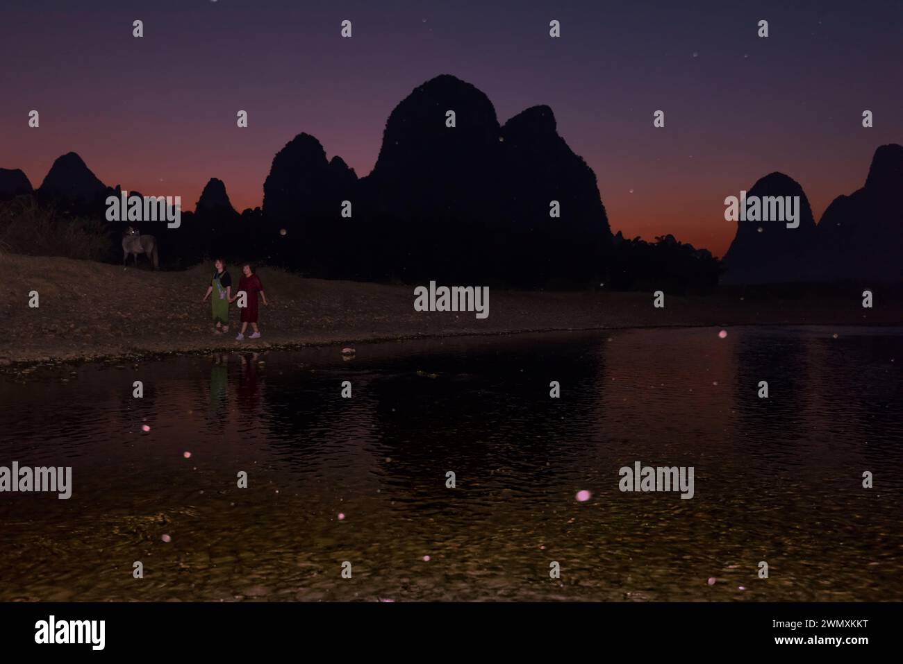 Yangshuo, Guilin, Guangxi, China - 23. Oktober 2023: 2023:zwei Touristen laufen in der Abenddämmerung entlang des Li-Flusses Stockfoto