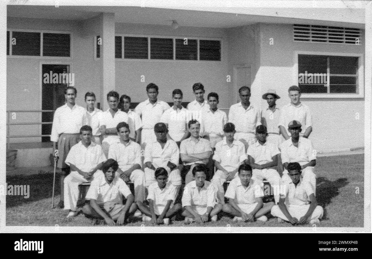 Ein originales Schwarzweißfoto von Mitgliedern des Singapore Cricket Teams aus dem Jahr 1955. Mr. R.G. Barker ist in der hinteren Reihe, zuletzt rechts. Stockfoto