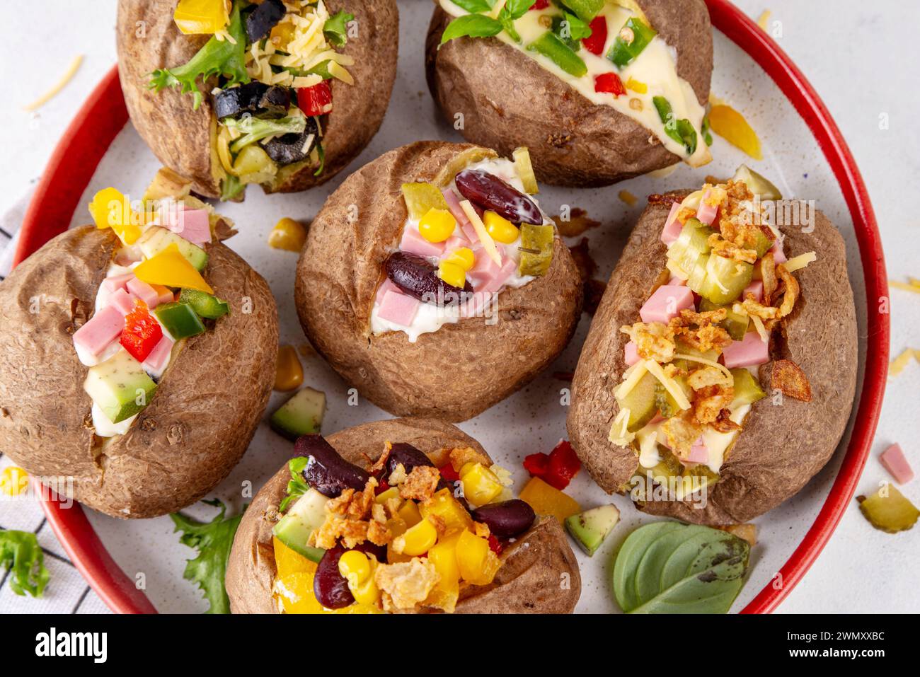 Hausgemachte Kartoffel mit verschiedenen Belägen - Fleisch, Würstchen, Gemüse, Käse, mit weißer Käsesauce, Kopierraum Stockfoto