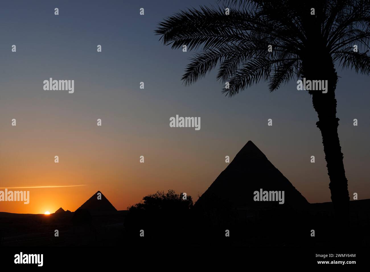 Ägypten, Kairo, Guiza, Memphis und seine Nekropole, die Pyramidenfelder von Gizeh bis Dahshur, die von der UNESCO zum Weltkulturerbe erklärt wurden, Sonnenuntergang auf den Pyramiden von Khephren und Menkaure Stockfoto