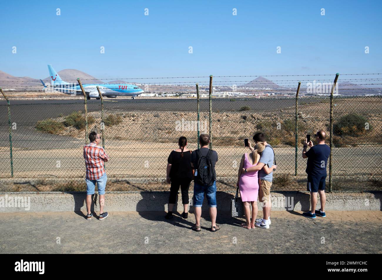 Touristen, die Flugzeuge am Ende der Start- und Landebahn beobachten tui Flugzeugabflug lanzarote Flughafen lanzarote, Kanarische Inseln, spanien Stockfoto