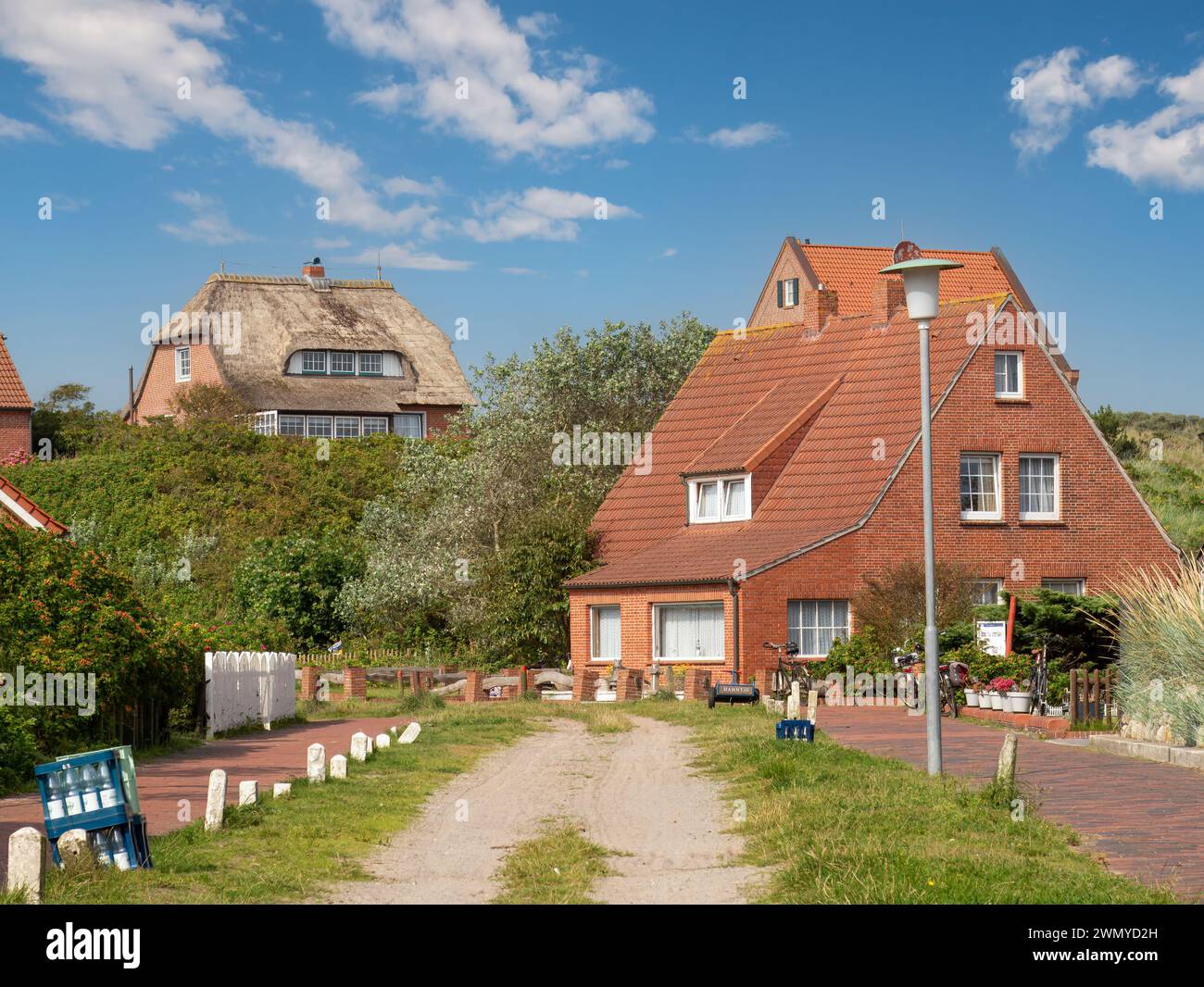 Straßenszene mit unbefestigter Straße und Häusern im Dorf der ostfriesischen Insel Juist, Niedersachsen Stockfoto
