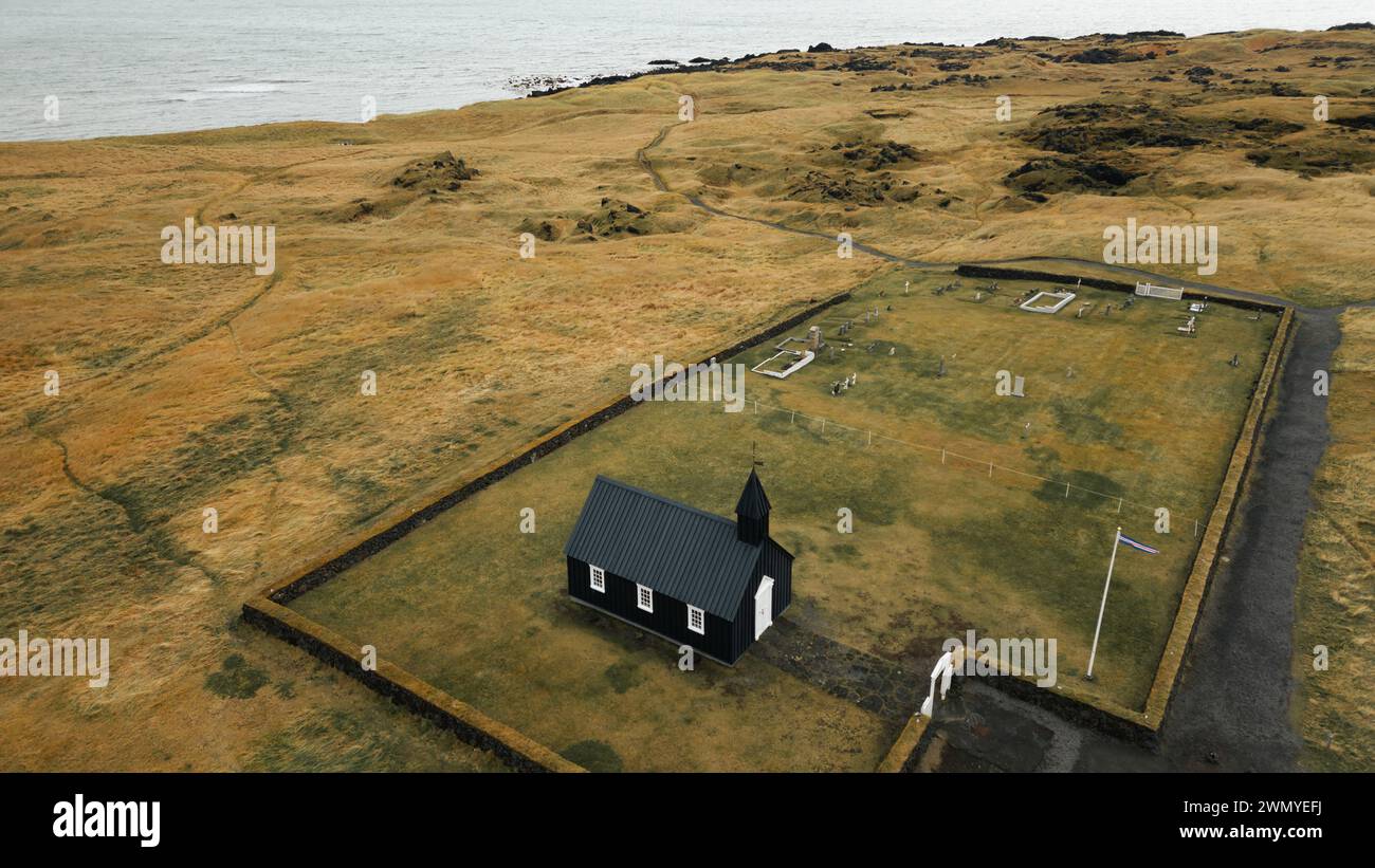 Ein Blick aus der Vogelperspektive auf die berühmte schwarze Kirche Búðakirkja in der abgelegenen Landschaft Islands, umgeben von kargen Feldern und dem Atlantischen Ozean im bac Stockfoto