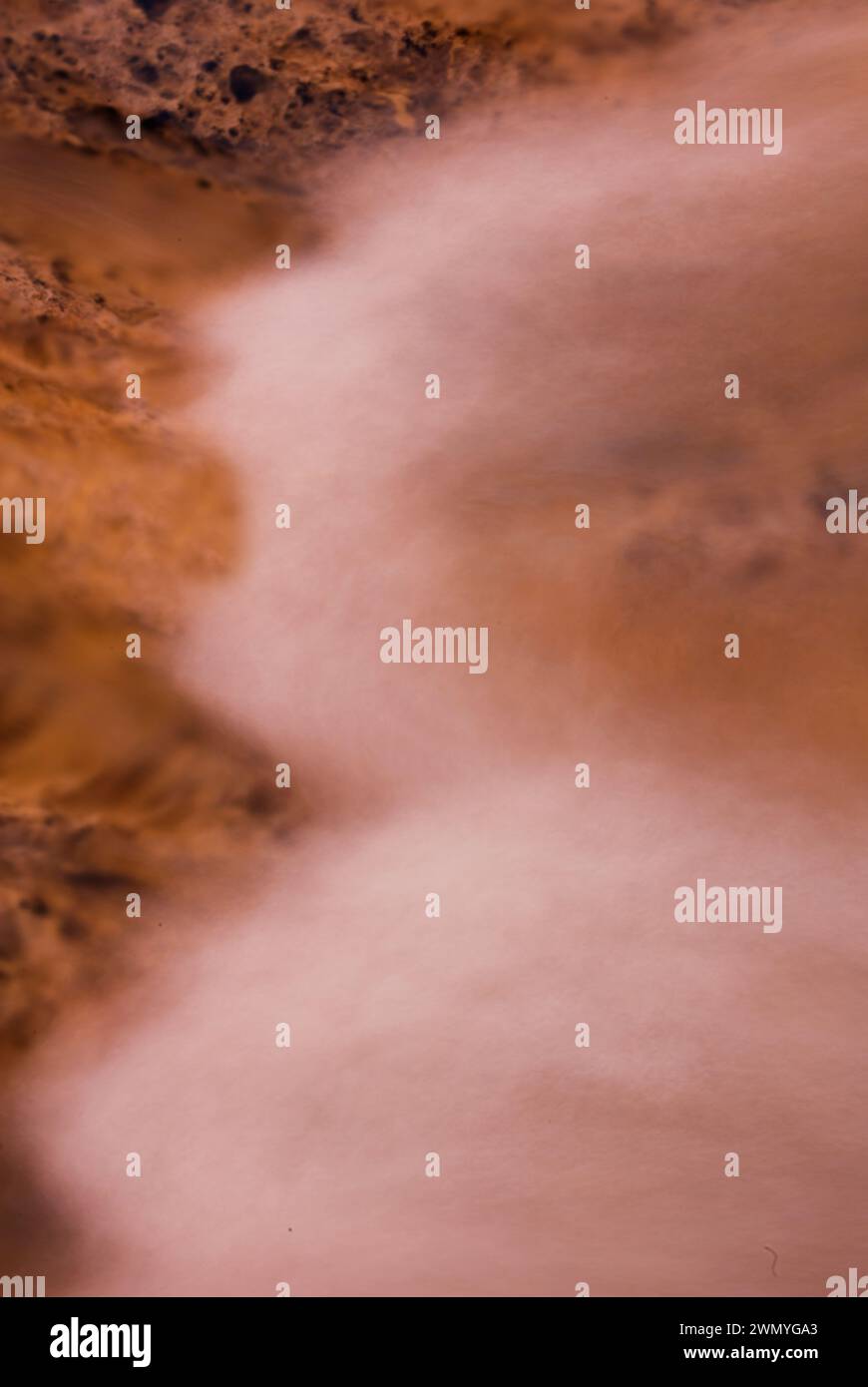 Abstrakte Nahaufnahme mit fließendem, wasserähnlichem Aussehen und felsenähnlichen Texturen in Sepia-Tönen. Stockfoto