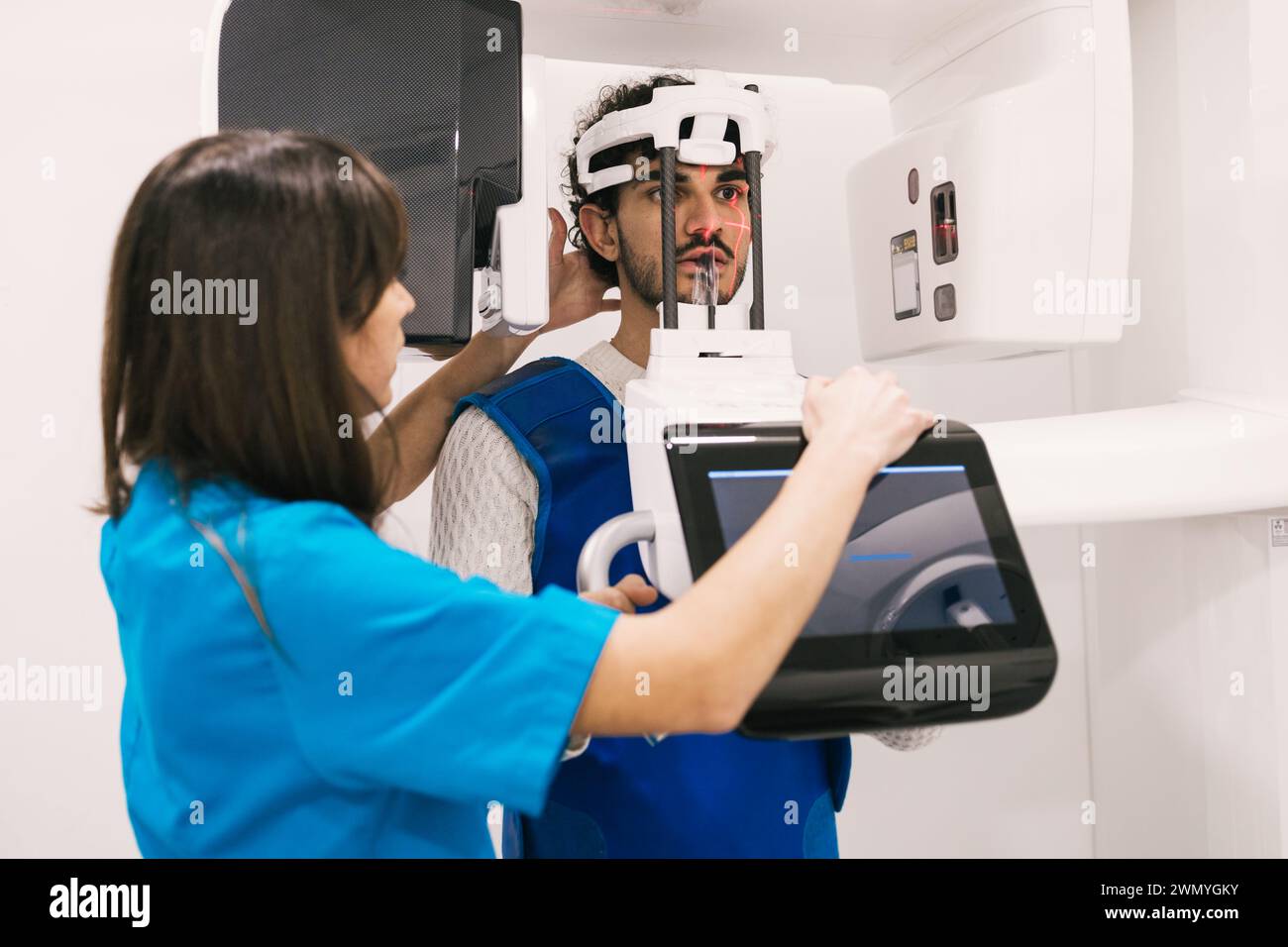 Der Zahnarzt unterstützt einen männlichen Patienten mit einer 3D-Röntgenaufnahme in einer Klinik. Stockfoto