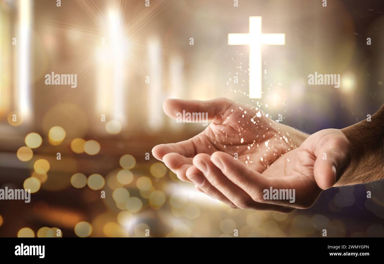 Hände einer religiösen Person mit einem Kreuz, das mit Glitzern und religiösem Hintergrund schwimmt. Stockfoto