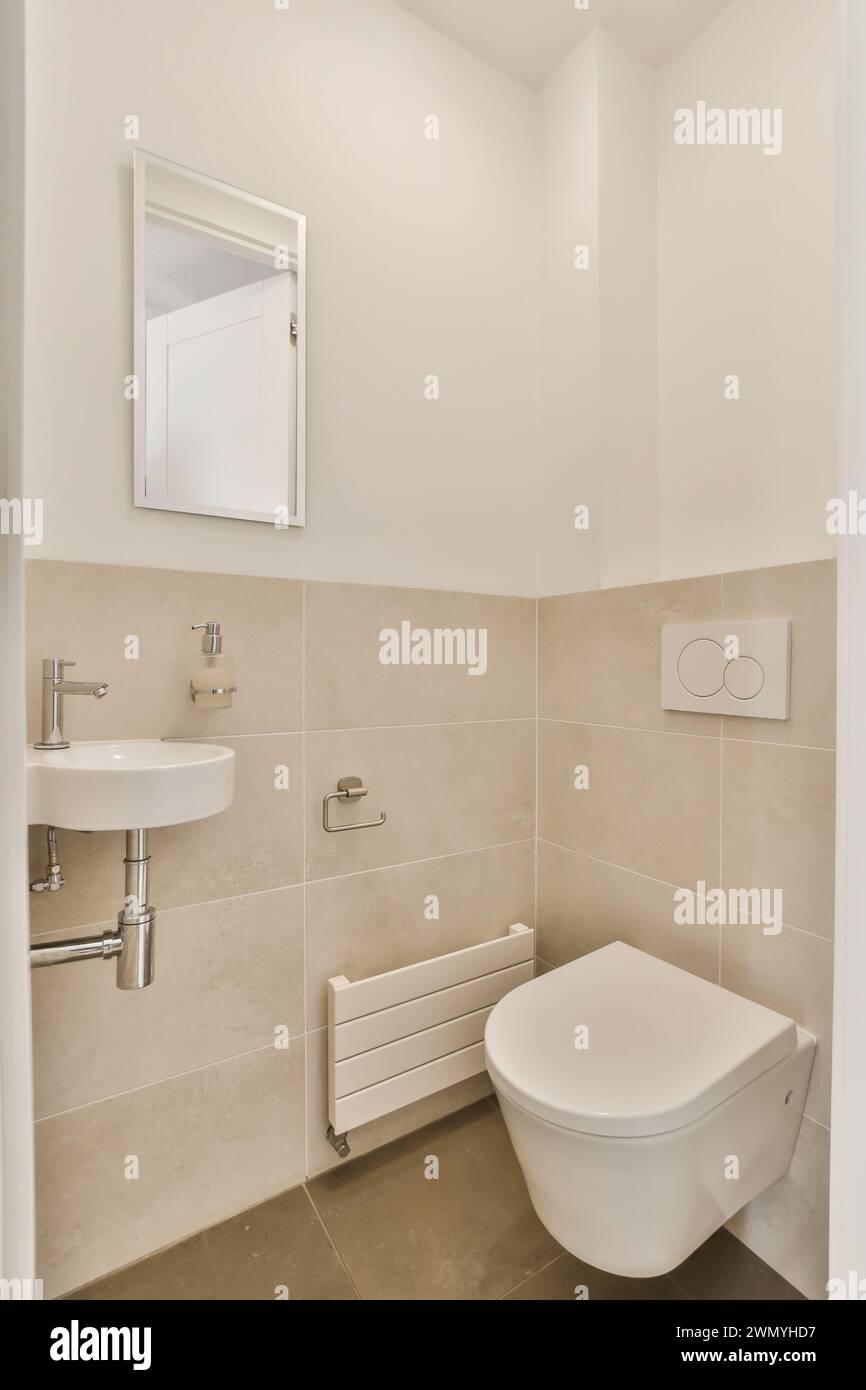 Modernes minimalistisches Badezimmer mit weißen Armaturen und beigefarbenen Fliesen. Stockfoto