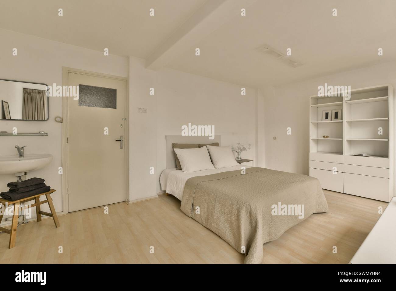 Ein Schlafzimmer mit einem Bett und einem Waschbecken Stockfoto