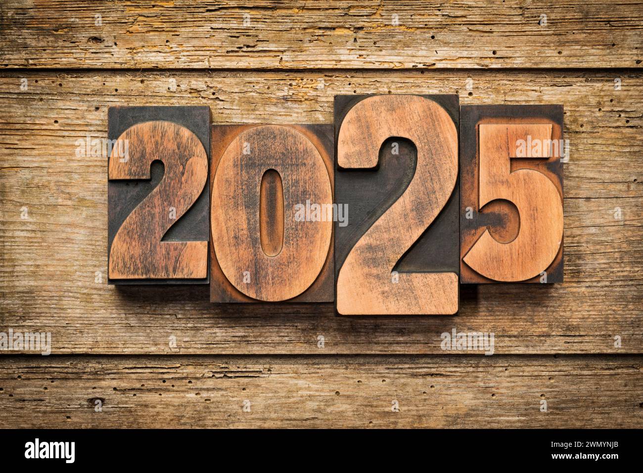 2025, Jahressatz mit Vintage-Buchdruckblöcken auf rustikalem Holzhintergrund Stockfoto