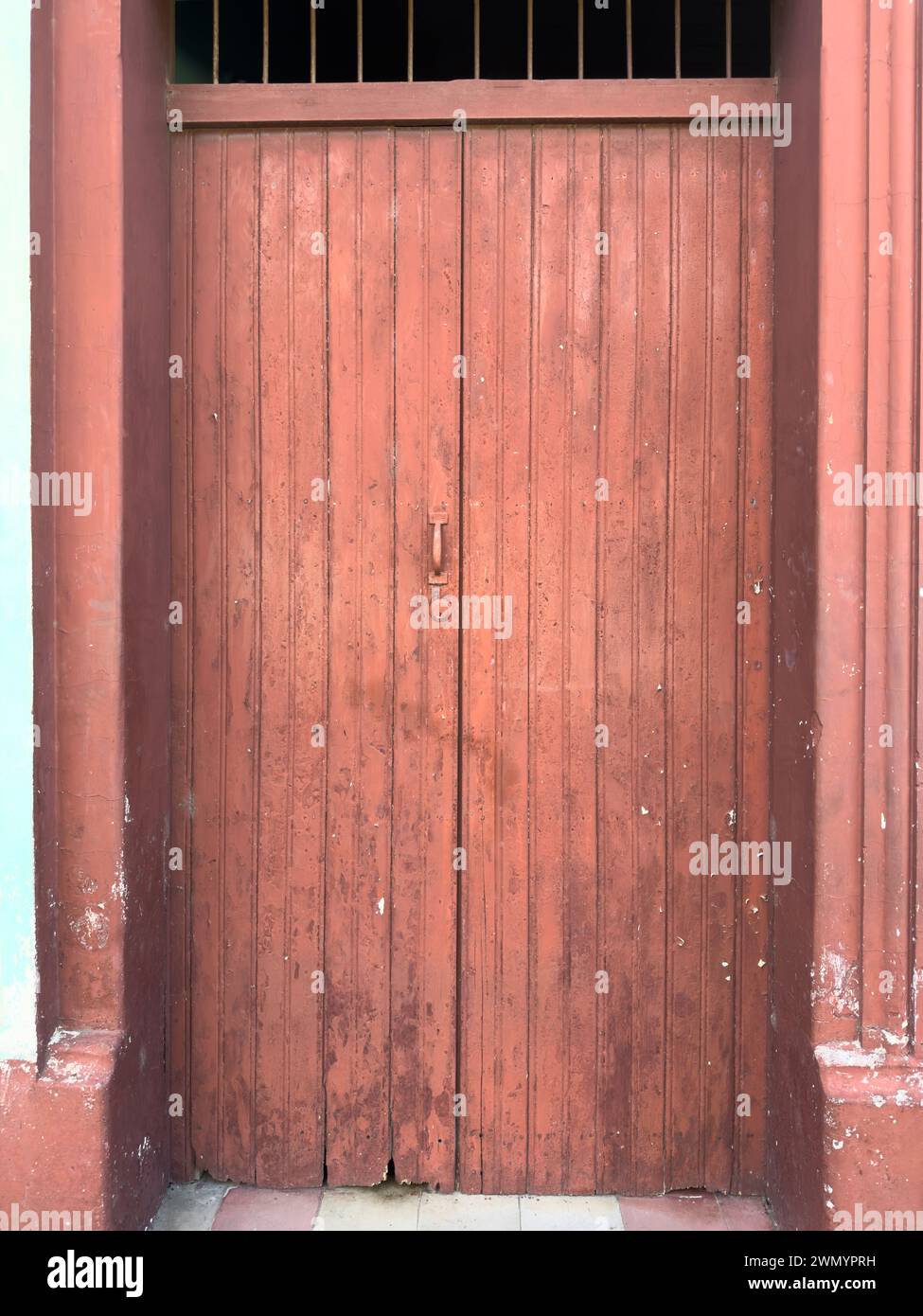 Graue Holztür rot mit beschädigter Farbe Stockfoto