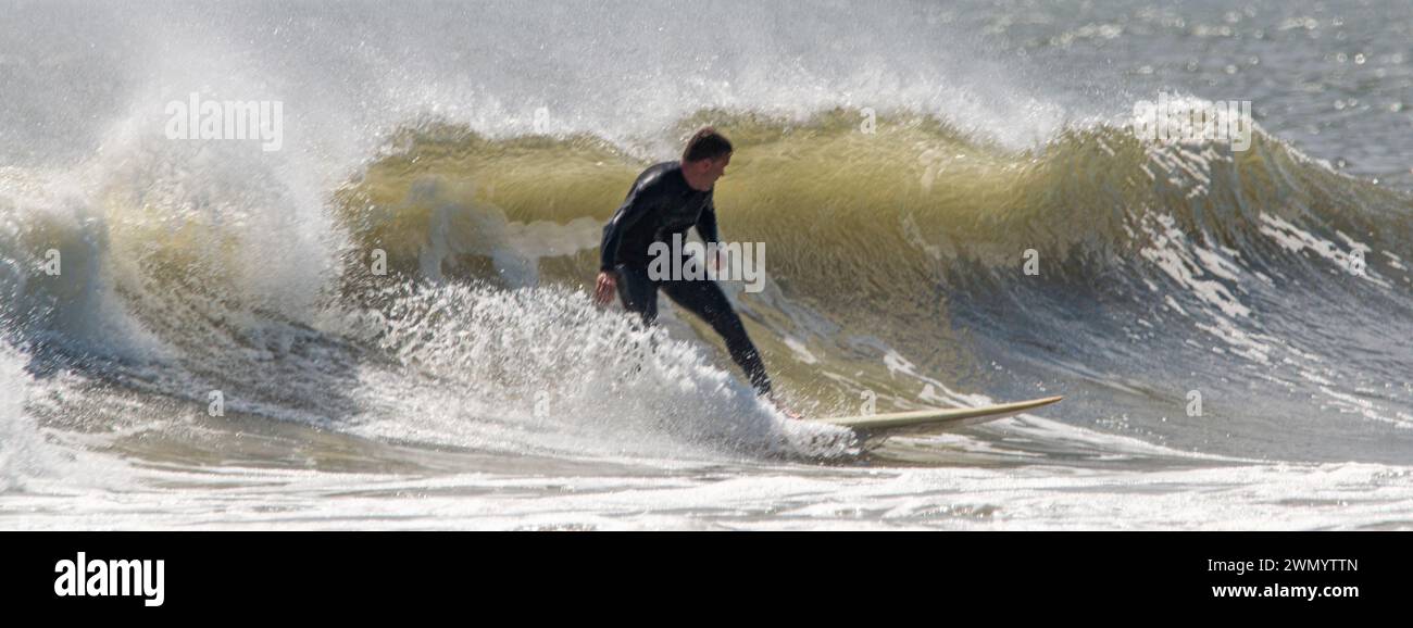 Giglo Beach, New York, USA - 13. August 2023: Horizontale Ansicht eines Surfers, der auf einer Welle vor der Küste von Long Island surft. Stockfoto