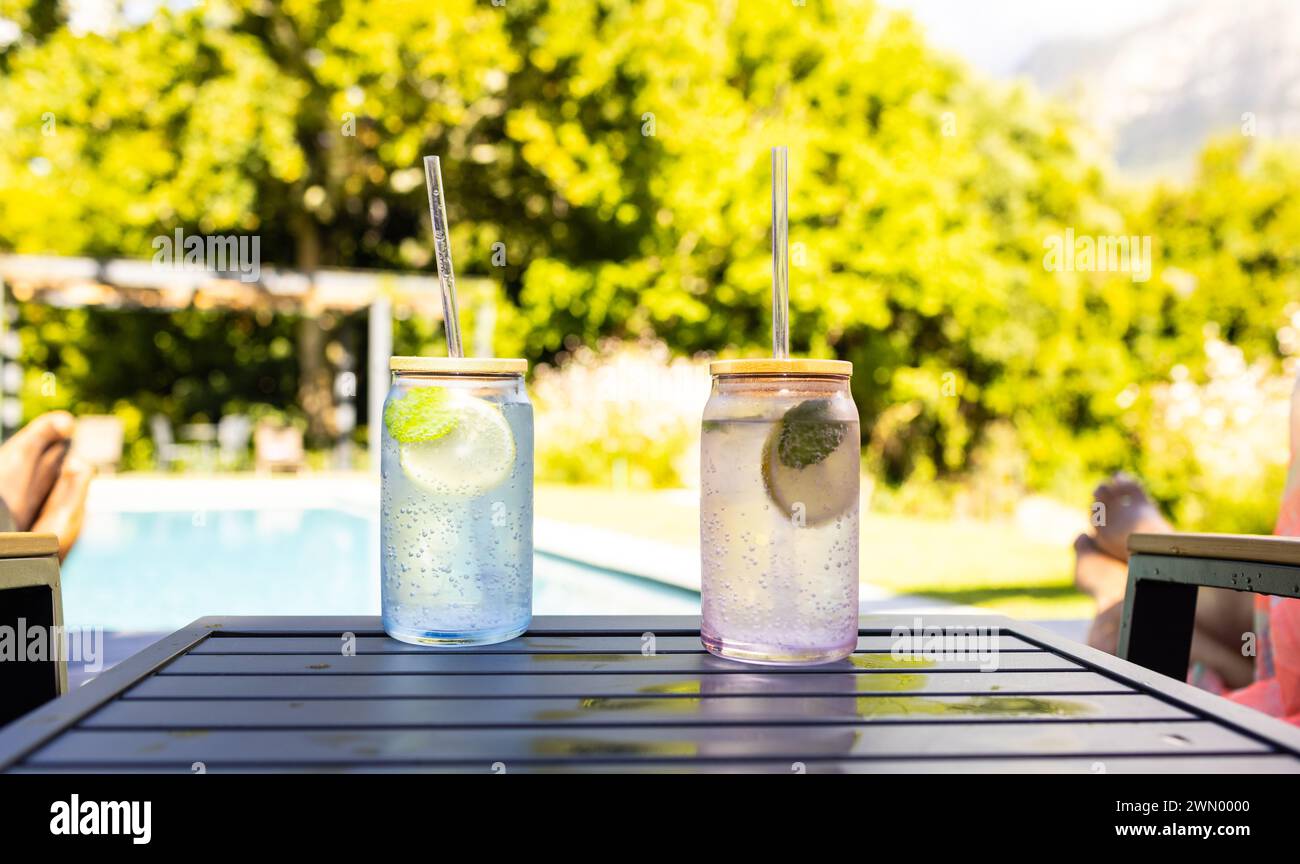 Zwei Gläser mit erfrischenden Getränken und Strohhalmen stehen auf einem Tisch im Freien Stockfoto