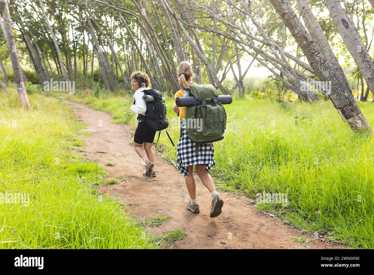 Zwei Frauen wandern auf einer Wanderung durch einen üppig grünen Wald Stockfoto