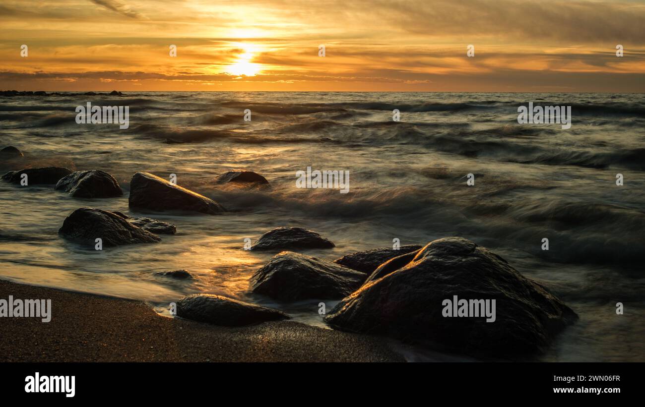 Veczemju Klintis, Latvija, wird am Abend zum Leben erweckt, wenn die Sonne über den felsigen Ufern untergeht und eine majestätische Szene schafft, in der die Schönheit und Ruhe der Natur zu sehen ist Stockfoto