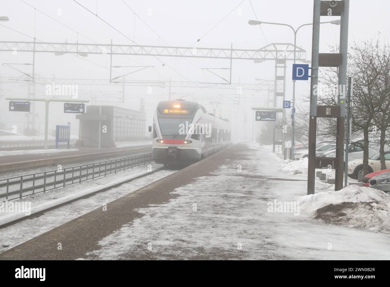 Nebeliger Wintertag in Finnland. Züge und Gebäude im Nebel Stockfoto