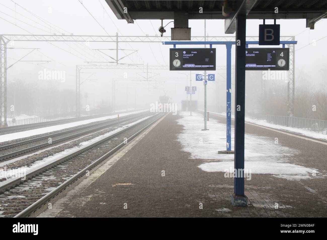 Nebeliger Wintertag in Finnland. Züge und Gebäude im Nebel Stockfoto