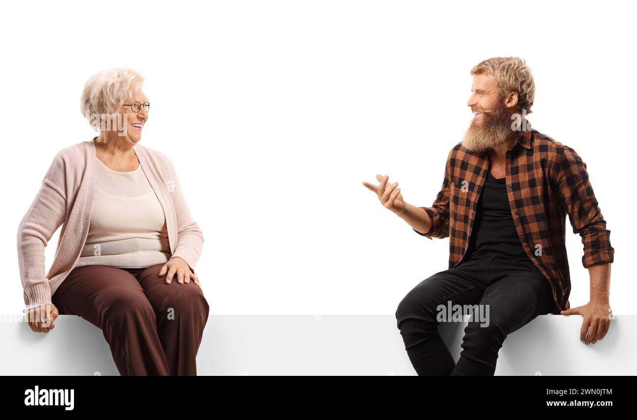 Ältere Frau, die mit einem bärtigen Kerl spricht und auf einer weißen Tafel sitzt, isoliert auf weißem Hintergrund Stockfoto