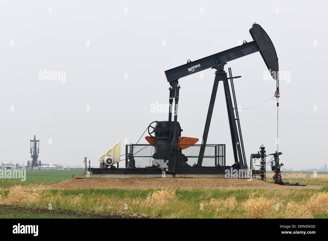 Das Anheben von Öl mit einem Pumpjack ist ein vertrauter Anblick in den Feldern rund um Edmonton, Alberta, Kanada Stockfoto