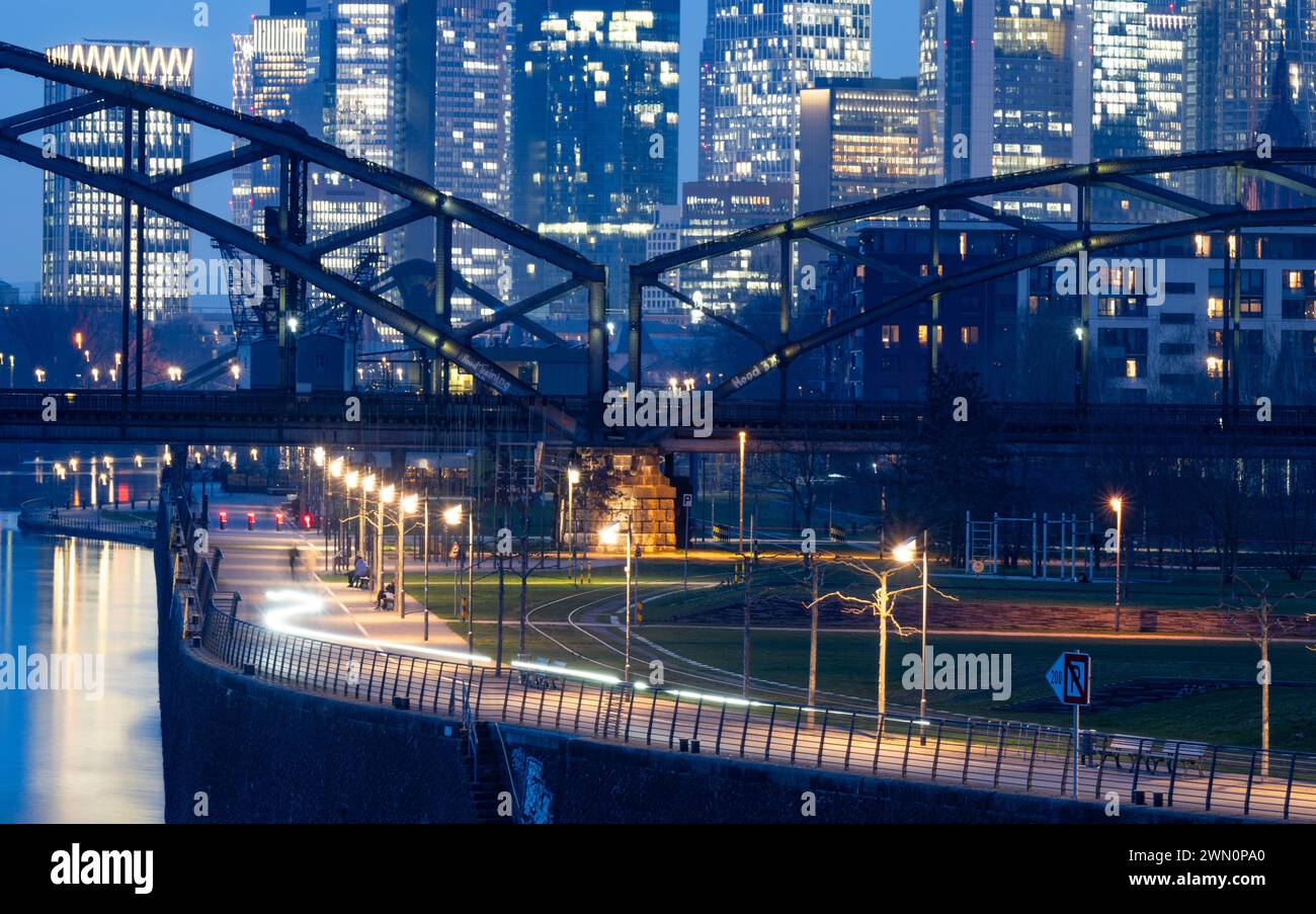 28. Februar 2024, Hessen, Frankfurt/Main: Hinter der Eisenbahnbrücke erheben sich die Wolkenkratzer der Frankfurter Bankenskyline in den Abendhimmel. Foto: Boris Roessler/dpa Stockfoto